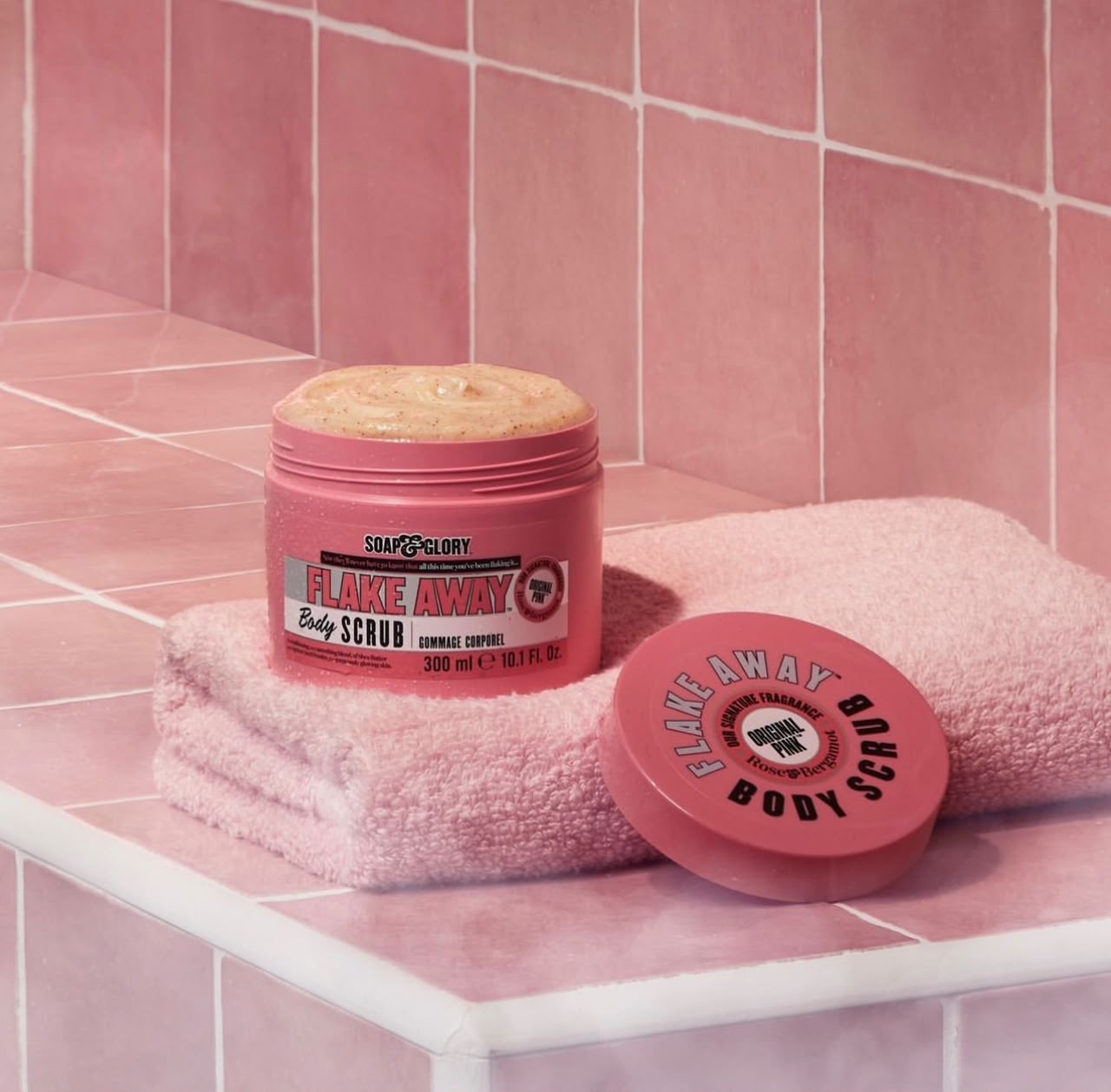 Soap & Glory Flake Away body scrub styled on pink tiles