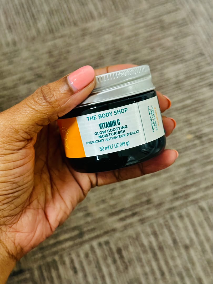 The Body Shop Vitamin C Glow Boosting Moisturiser 50ml jar held in hand, available in Dar es Salaam